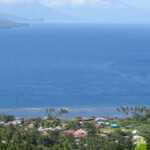 Pulau Ternate: palme, mare e coni vulcanici all’orizzonte View of Pulau Moti and Pulau Makian from Ternate in Indonesia Maluku Archipelago