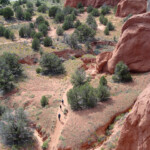 In vista il Grand Parade Trail From Angels Palace Trail a view of hikers walking Grand Parade Trail in Kodachrome Basin State Park in Utah USA