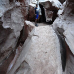 Walking under a Boulder in the Second Slot Section of Little Wild Horse Canyon in the San Rafael Swell Utah USA