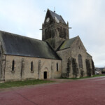 La piazza e la famosa chiesa di Sainte Mère Eglise Church, Sainte Mere Eglise, John Steele Parachute, Normandy, France